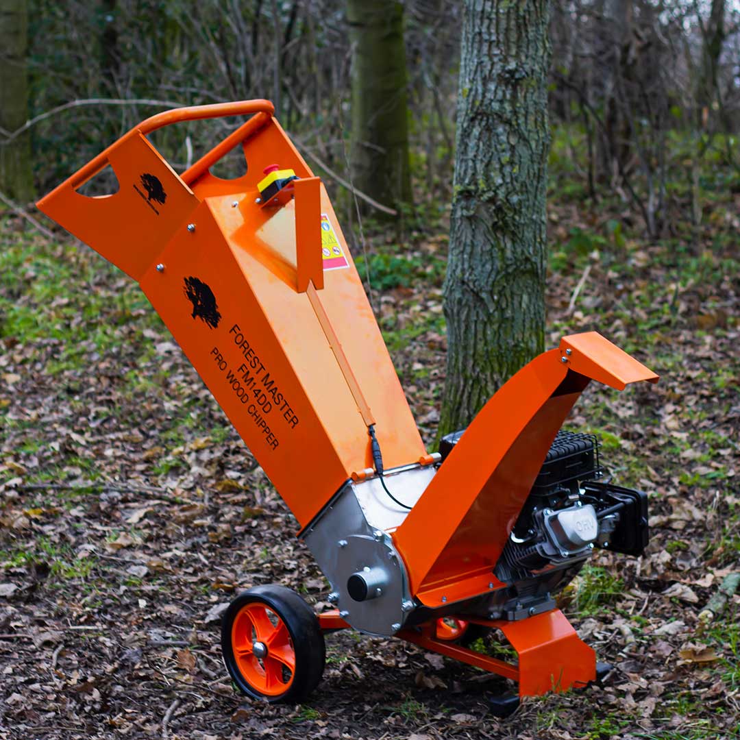 orange wood chipper amongst a forest setting